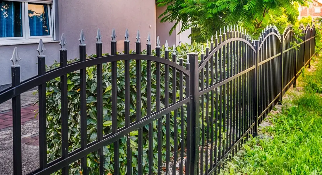black metal fence with decorative spear top design in a yard