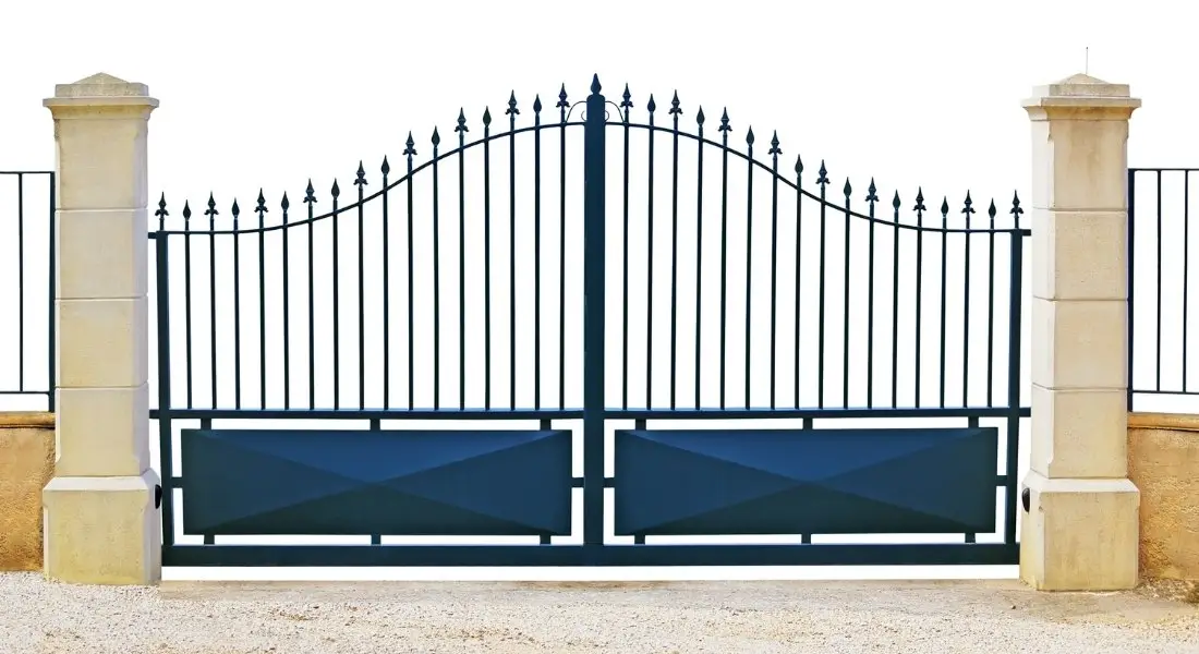 black wrought iron driveway gate with stone pillars