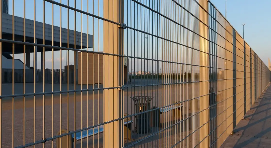 tall metal security fence around commercial property