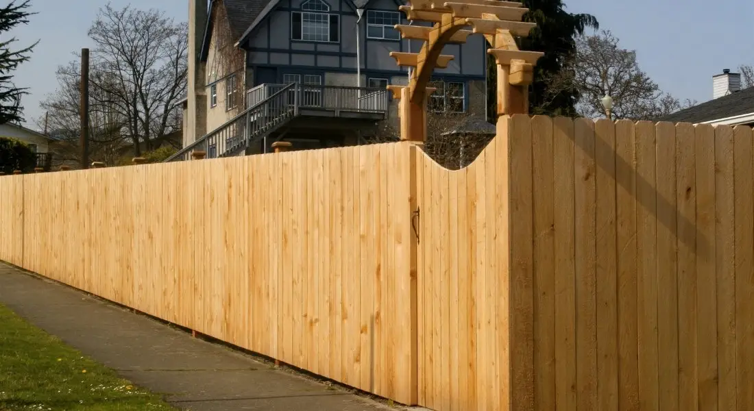 tall wood privacy fence with gate and decorative arbor