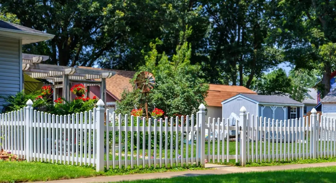 white vinyl picket fence enclosing a garden in residential yard