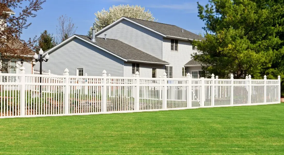 white vinyl picket fence surrounding suburban backyard
