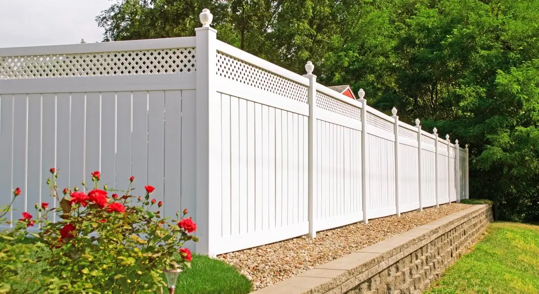 white vinyl privacy fence with lattice top on raised yard