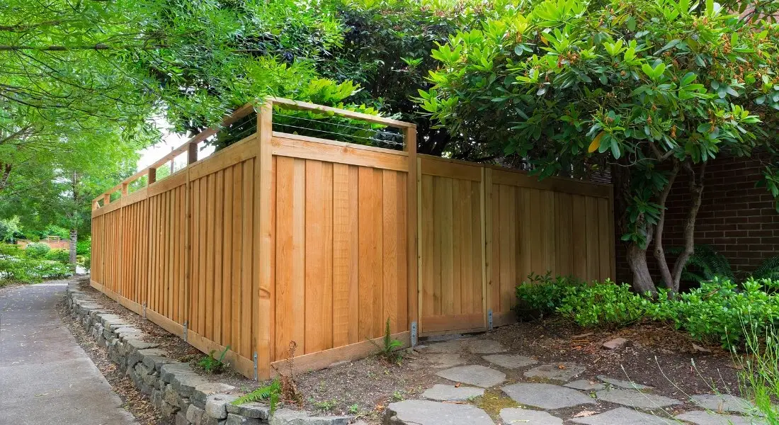 wood privacy fence with modern horizontal design built along a garden path